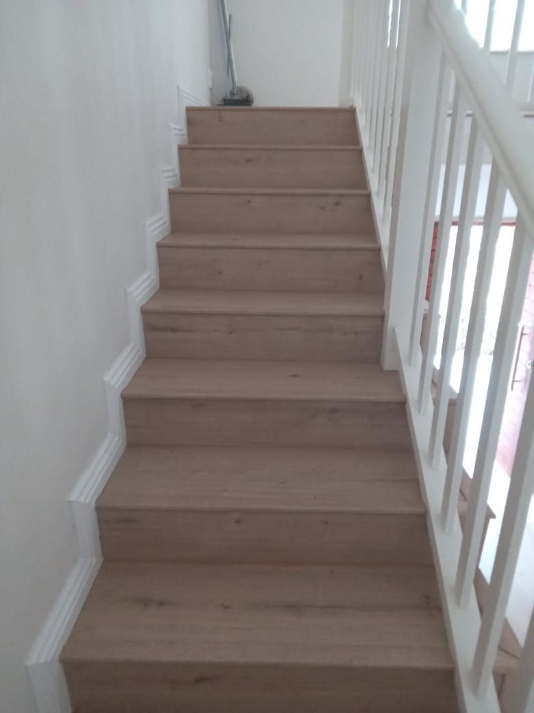 The stairs are made of wood and have a white railing.