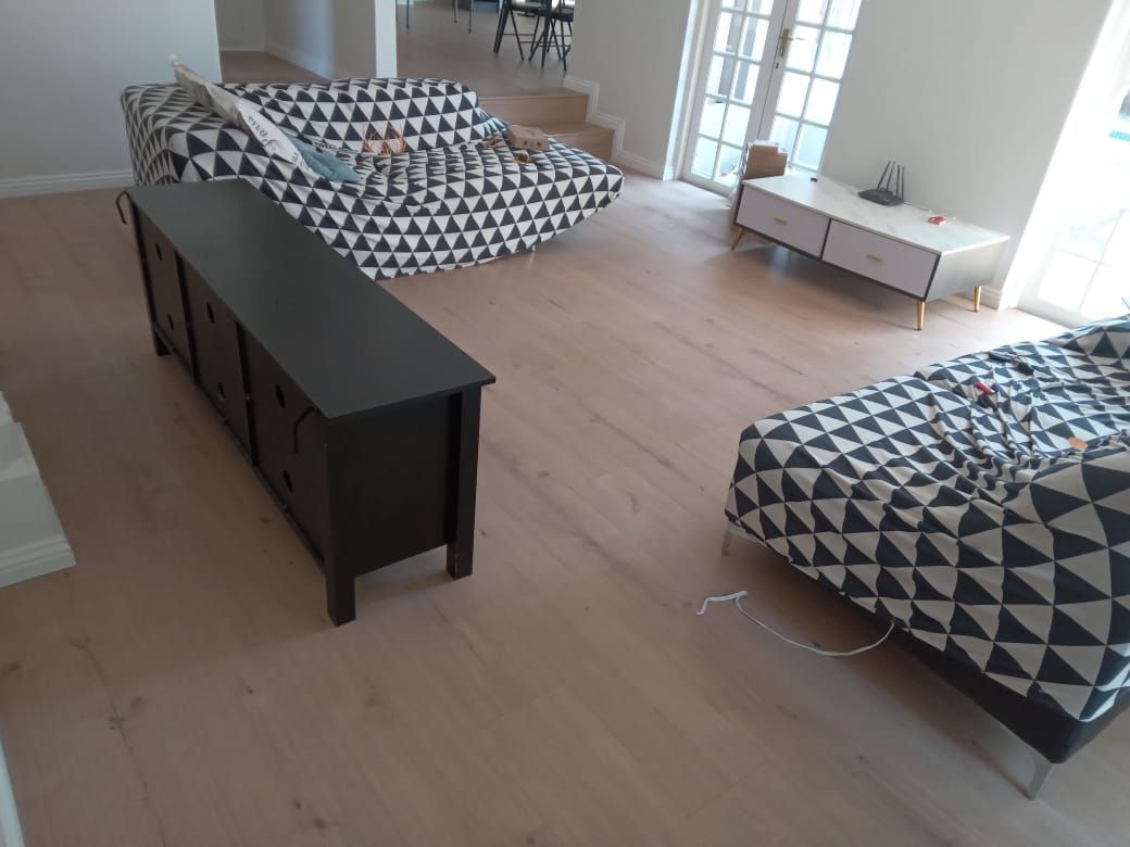 A living room with a couch , chair , and dresser.