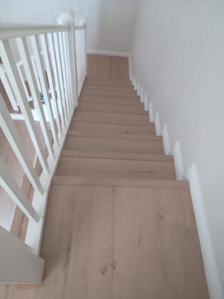 The stairs are made of wood and have a white railing.
