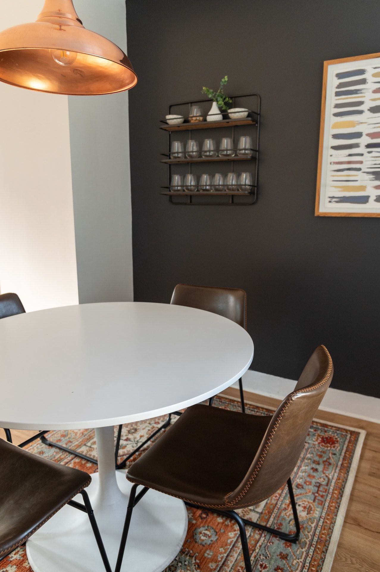 A dining room with a white table and brown chairs.