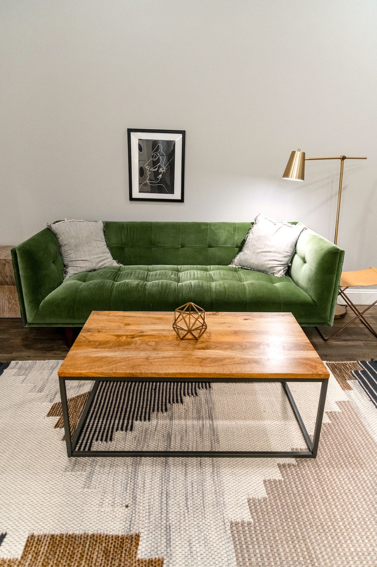A living room with a green couch and a wooden coffee table.