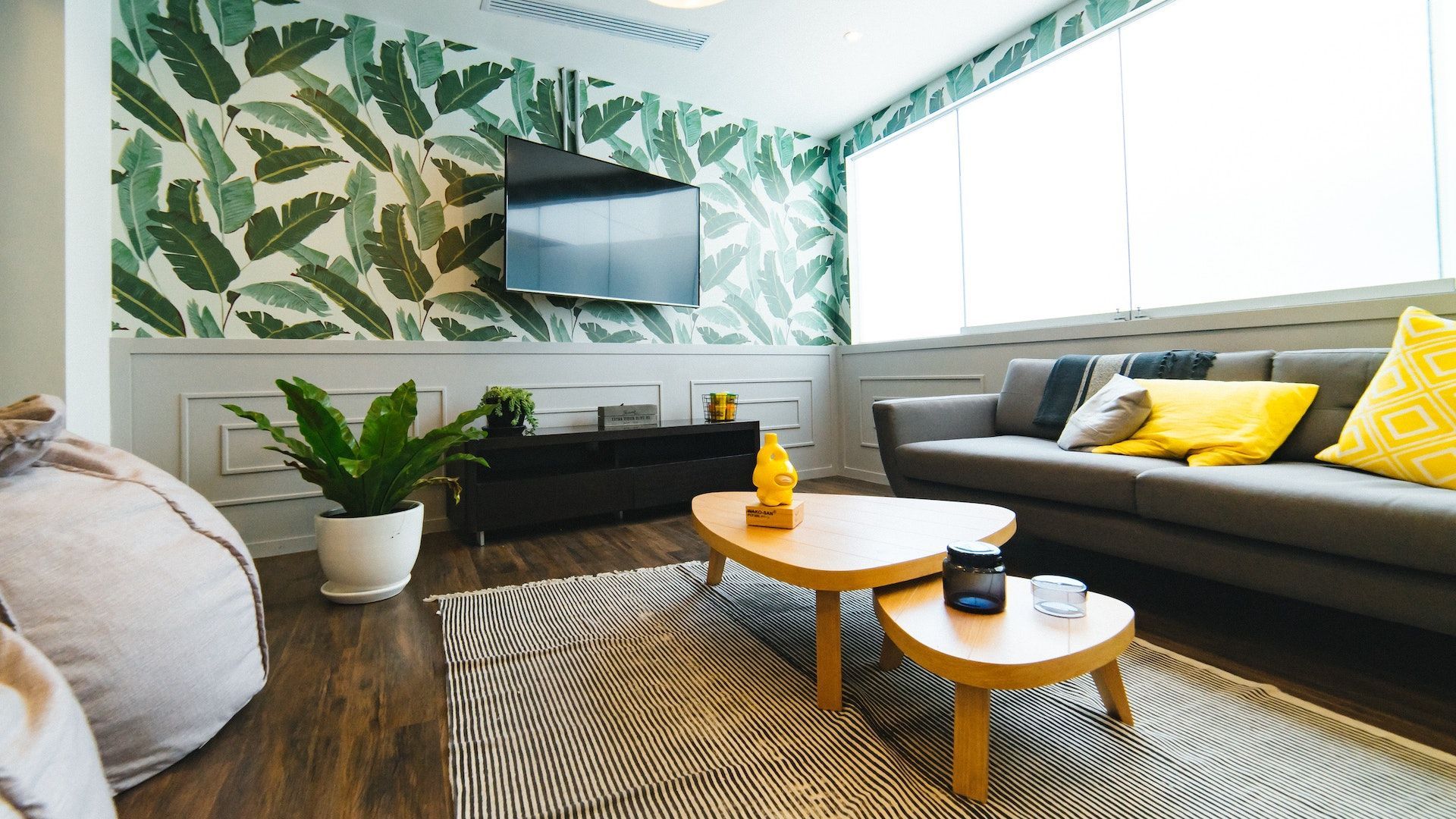 A living room with a couch , two coffee tables and a flat screen tv.