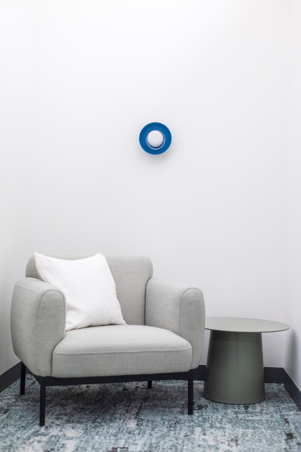 A chair and a table in a room with a blue circle on the wall.