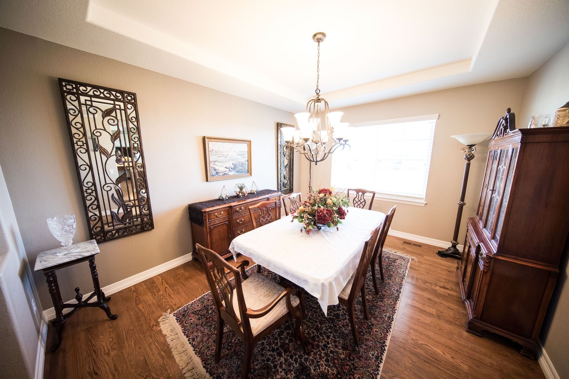 A dining room with a long table and chairs and a chandelier.