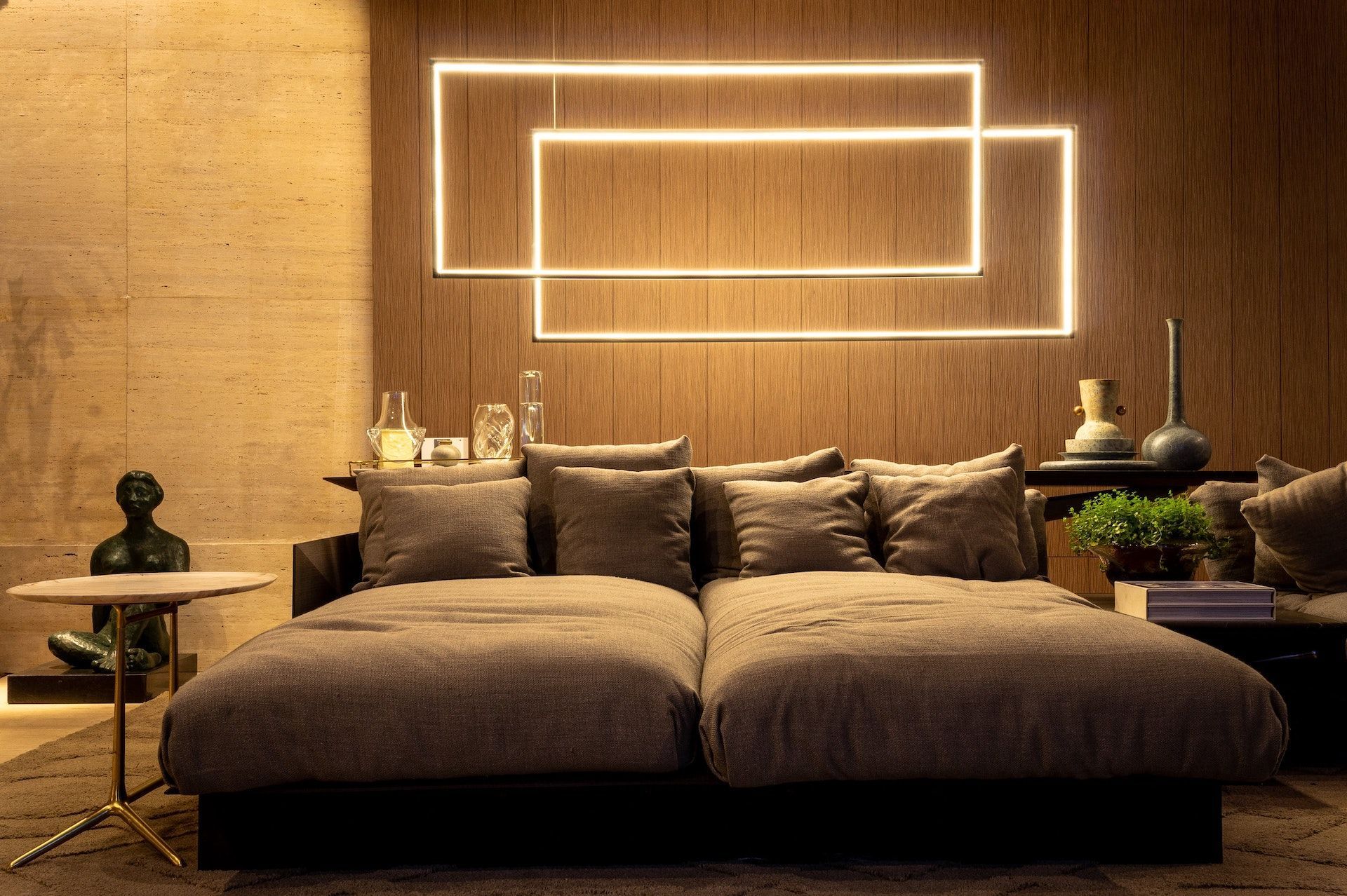 A living room with a couch , table , and a wooden wall.