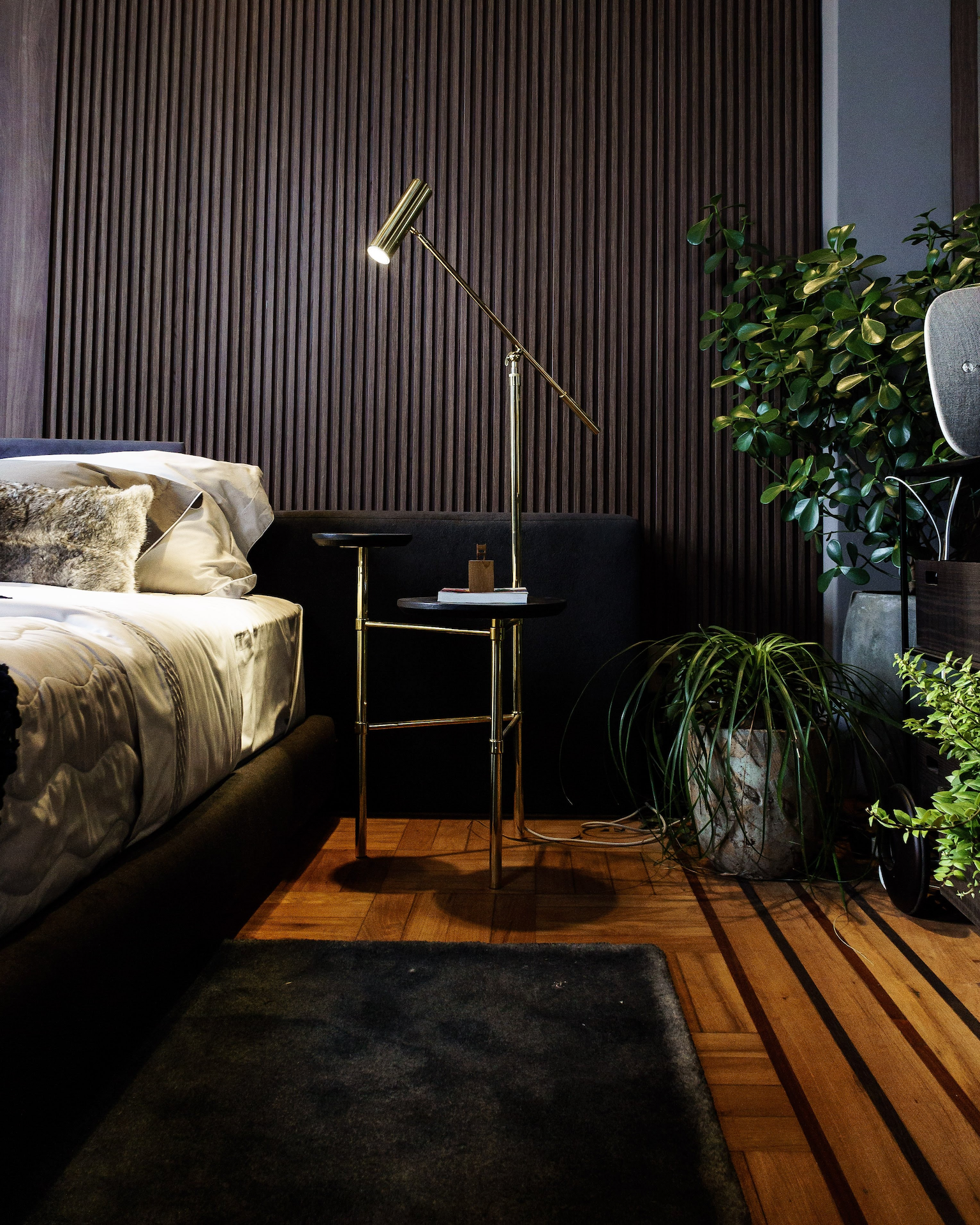 A bedroom with a bed and a lamp on the nightstand