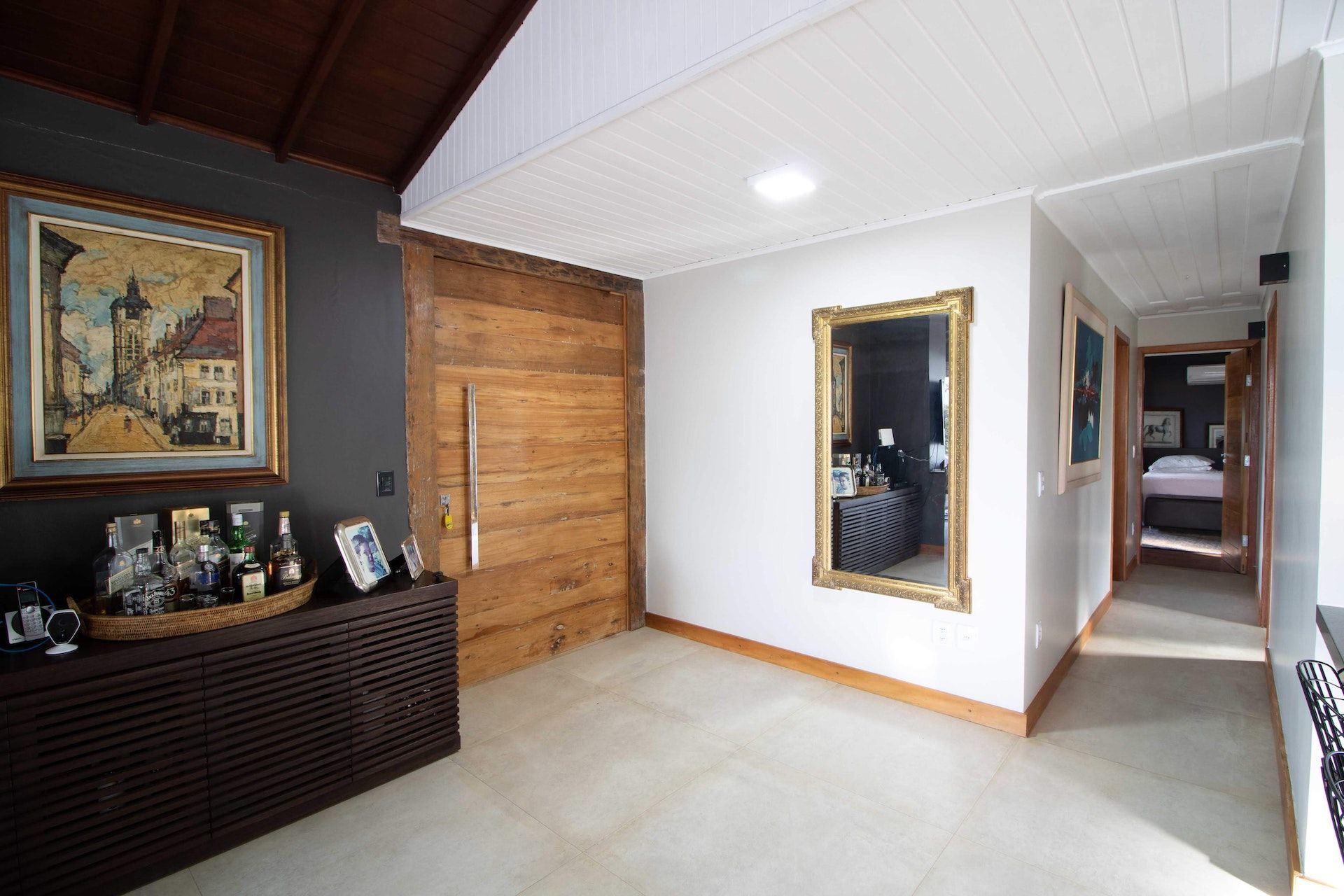 A hallway with a wooden door and two mirrors