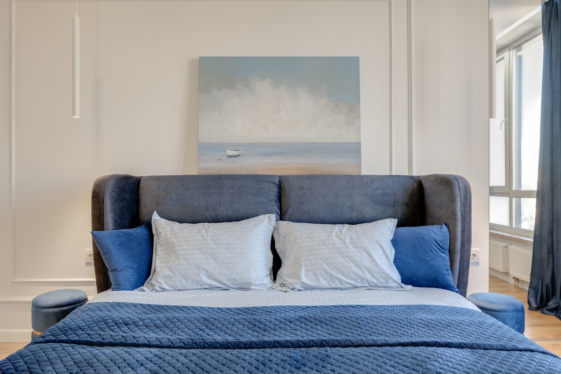 There is a painting on the wall above the bed in the bedroom.