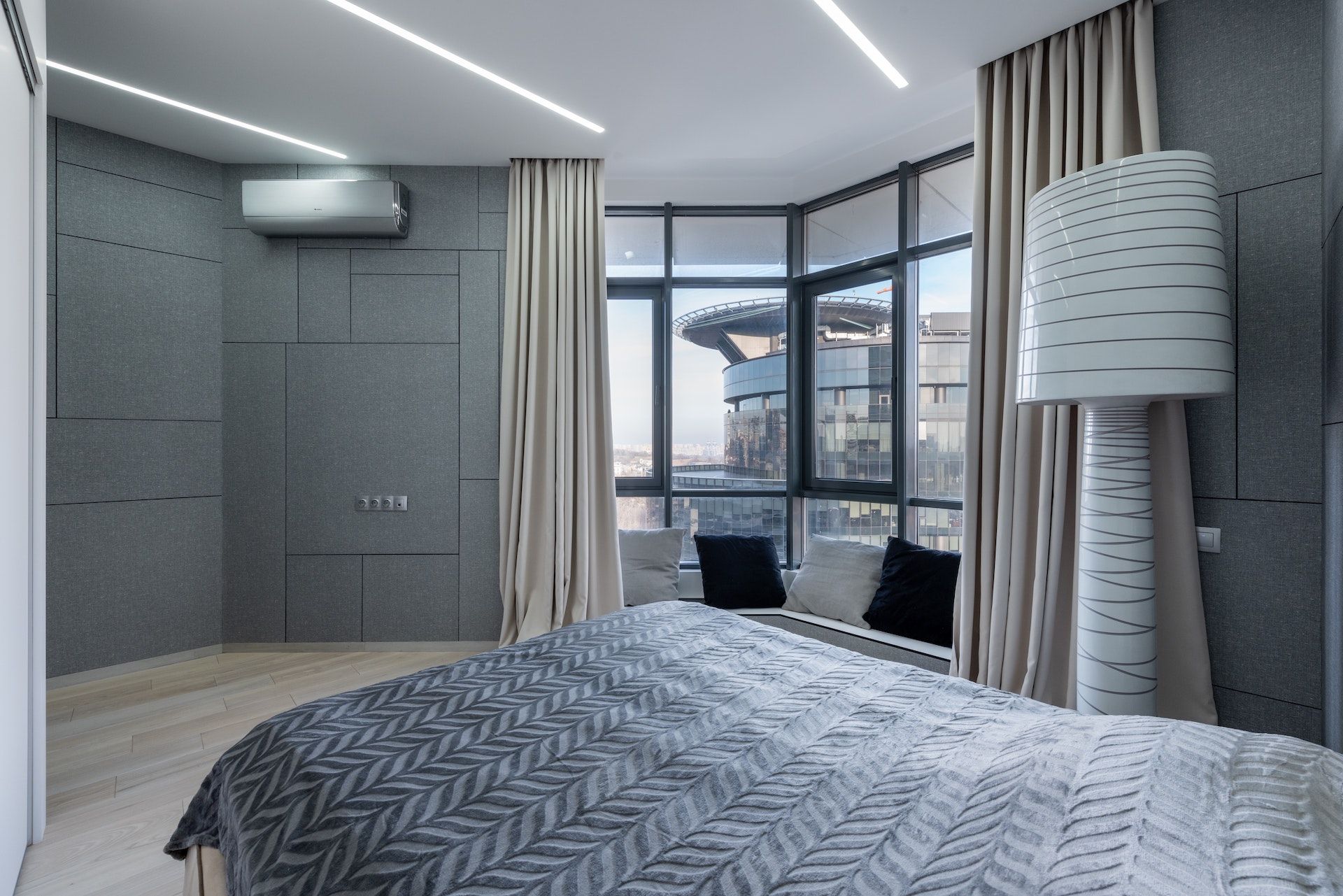 A bedroom with a large bed and a lamp.