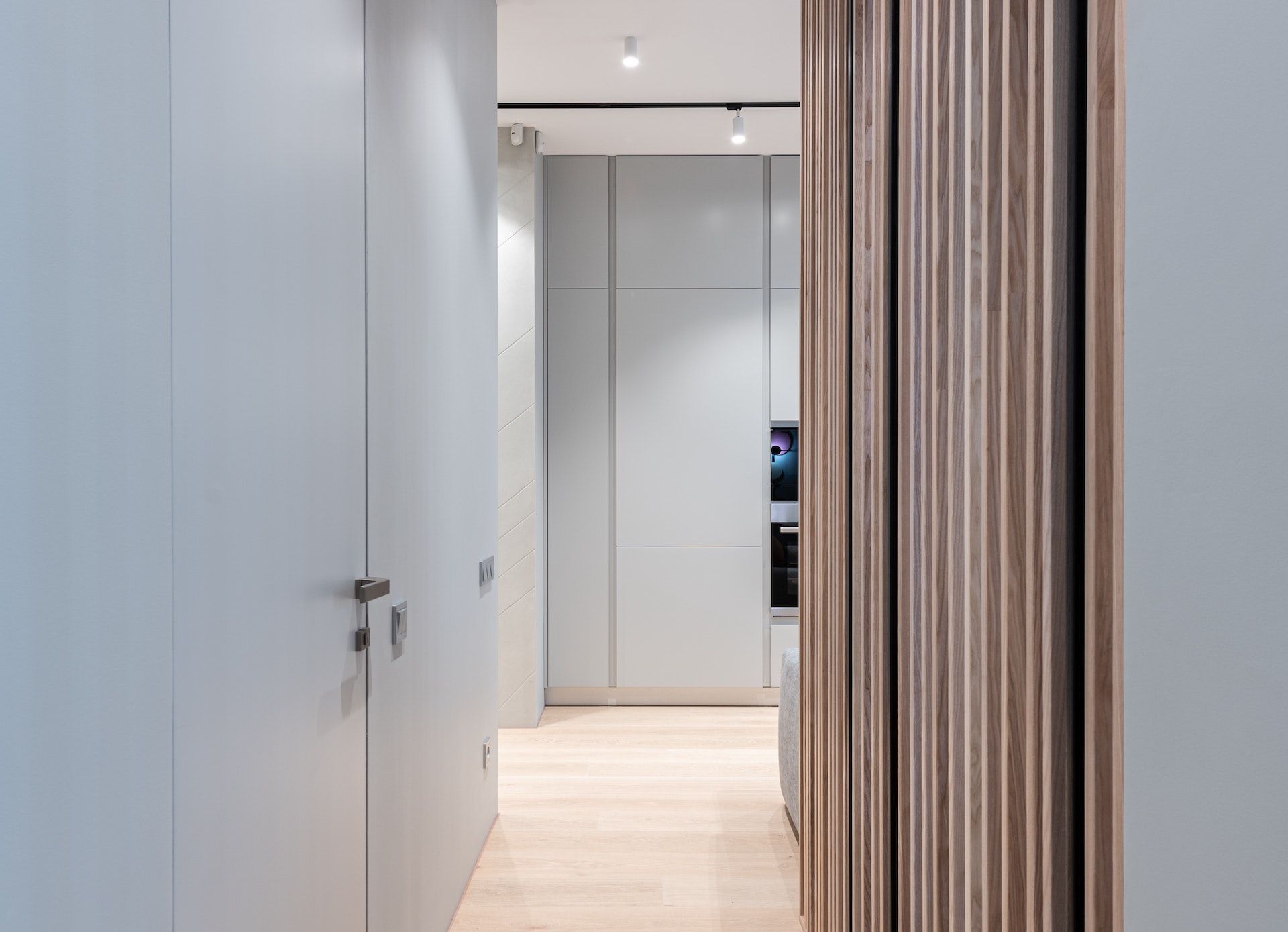 A hallway in a house with a wooden divider between two rooms.