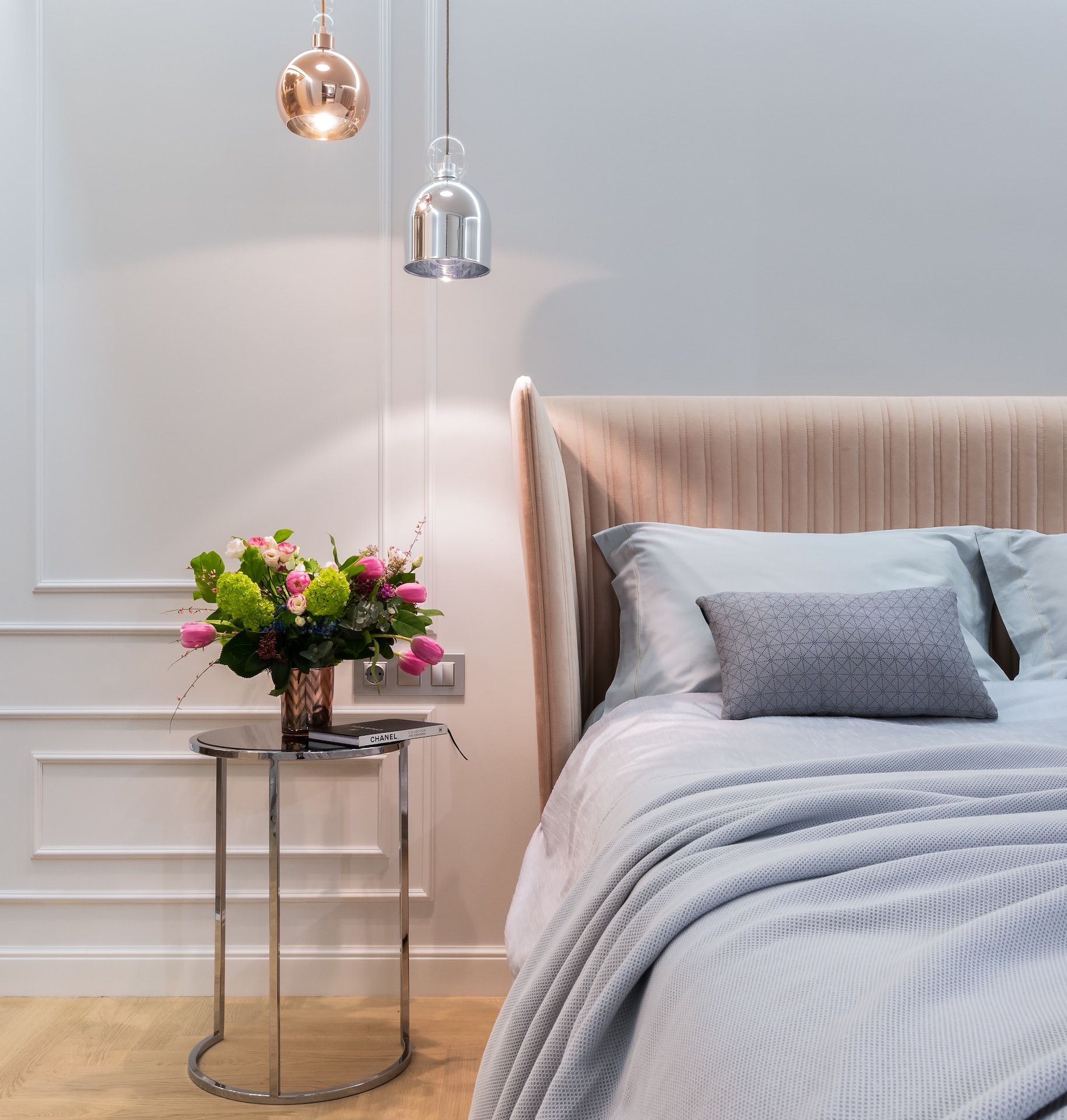 A bedroom with a bed and a table with flowers on it