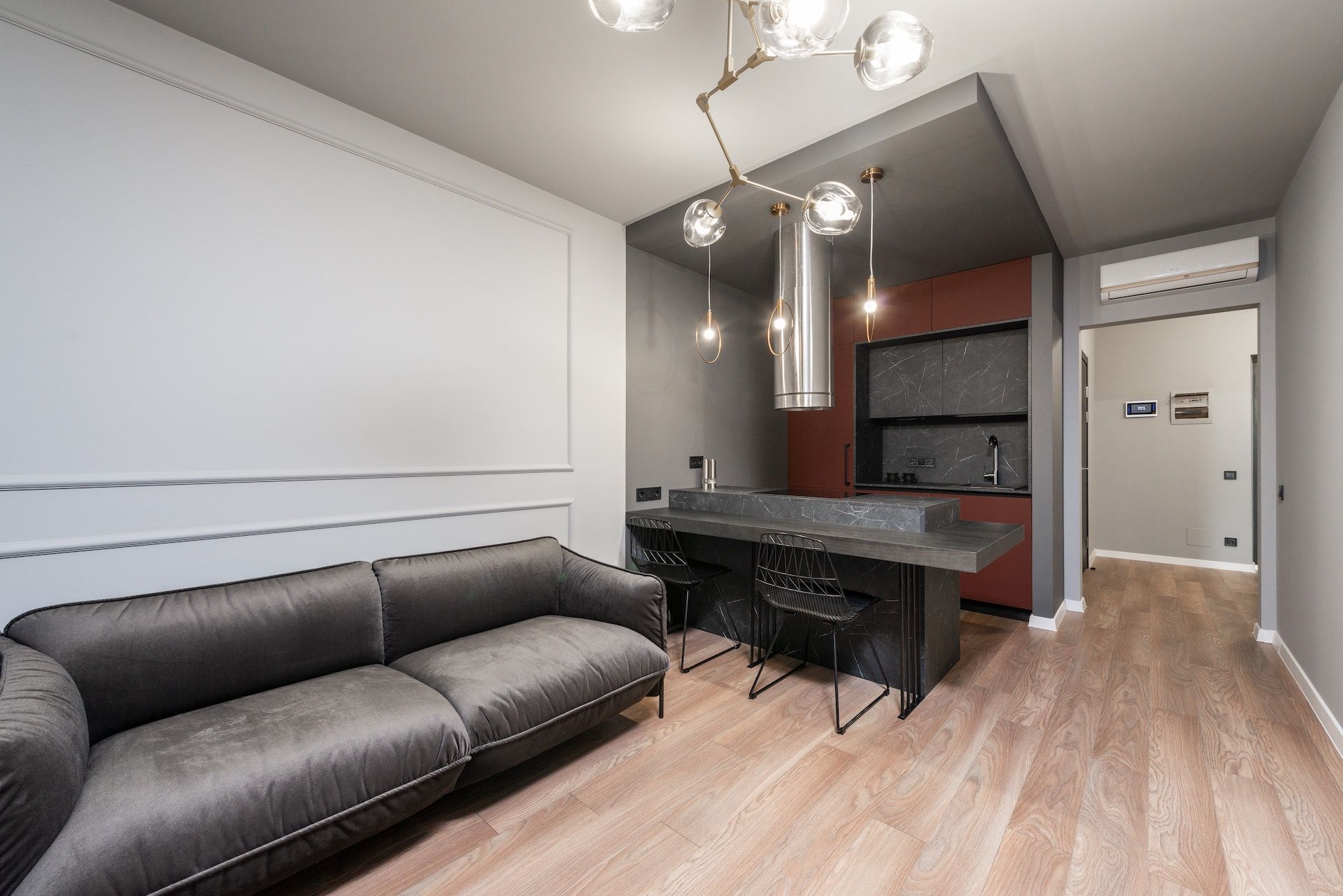 A living room with a couch and a kitchen in the background.