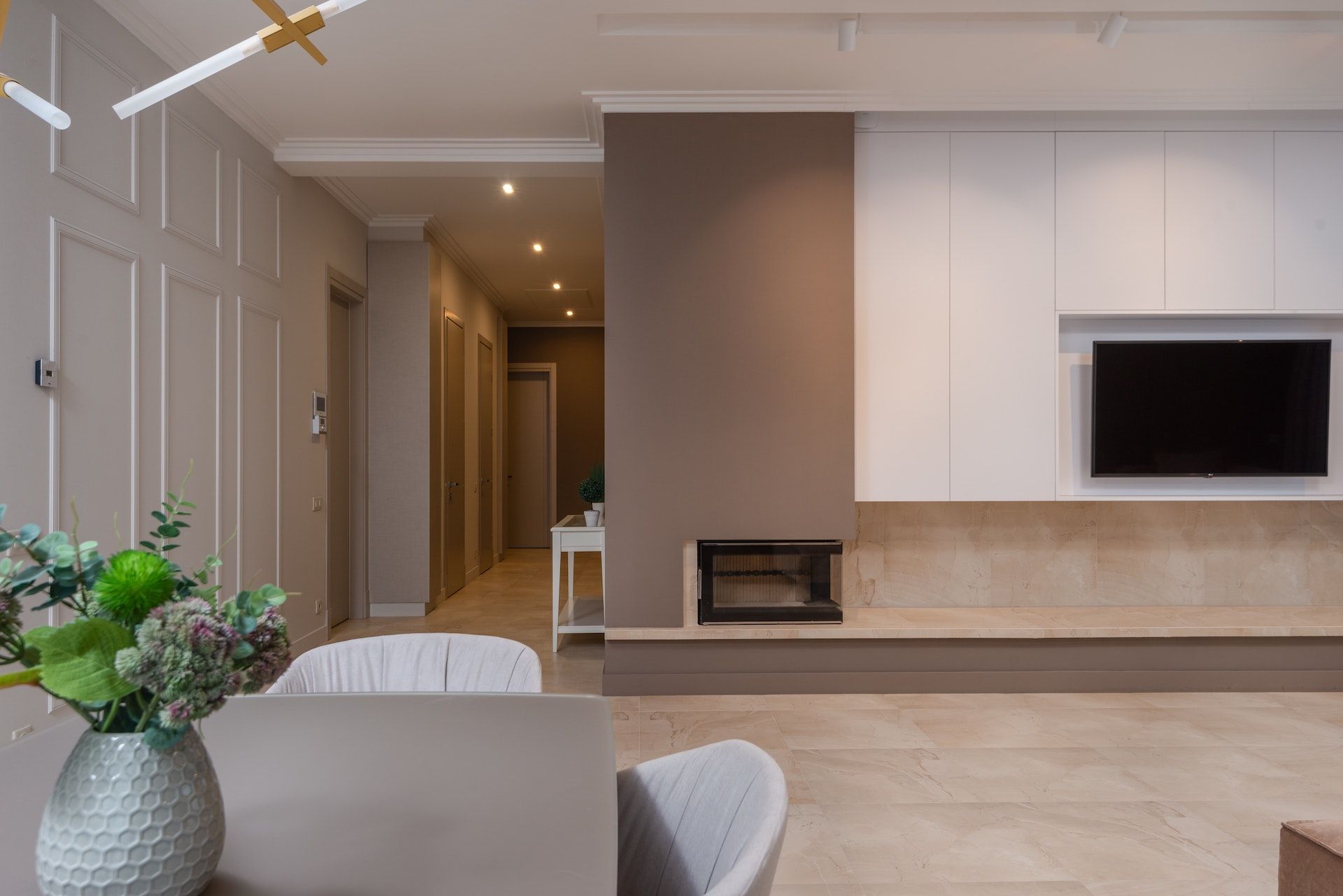 A living room with a table , chairs , fireplace and television.