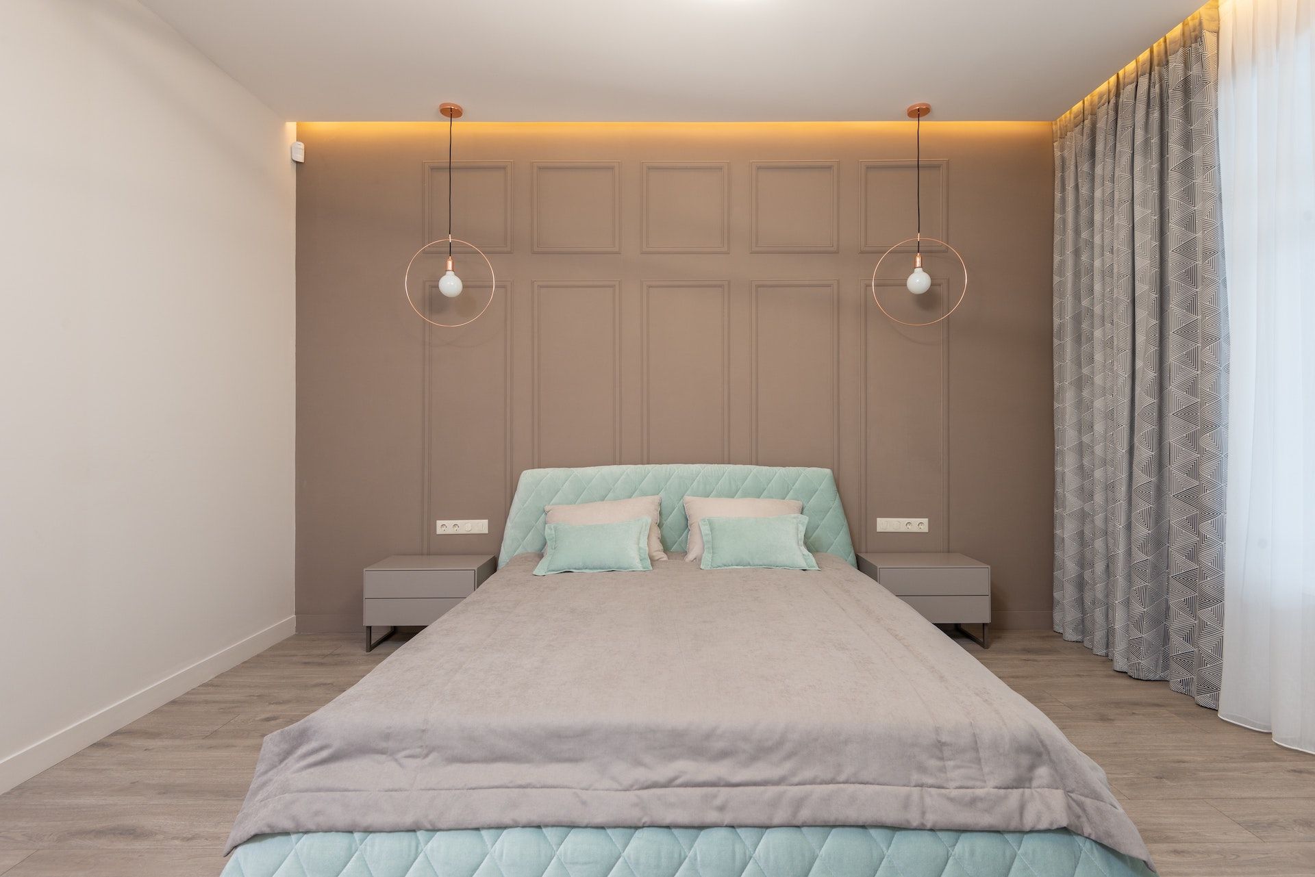 A bedroom with a bed , nightstands , and a window.