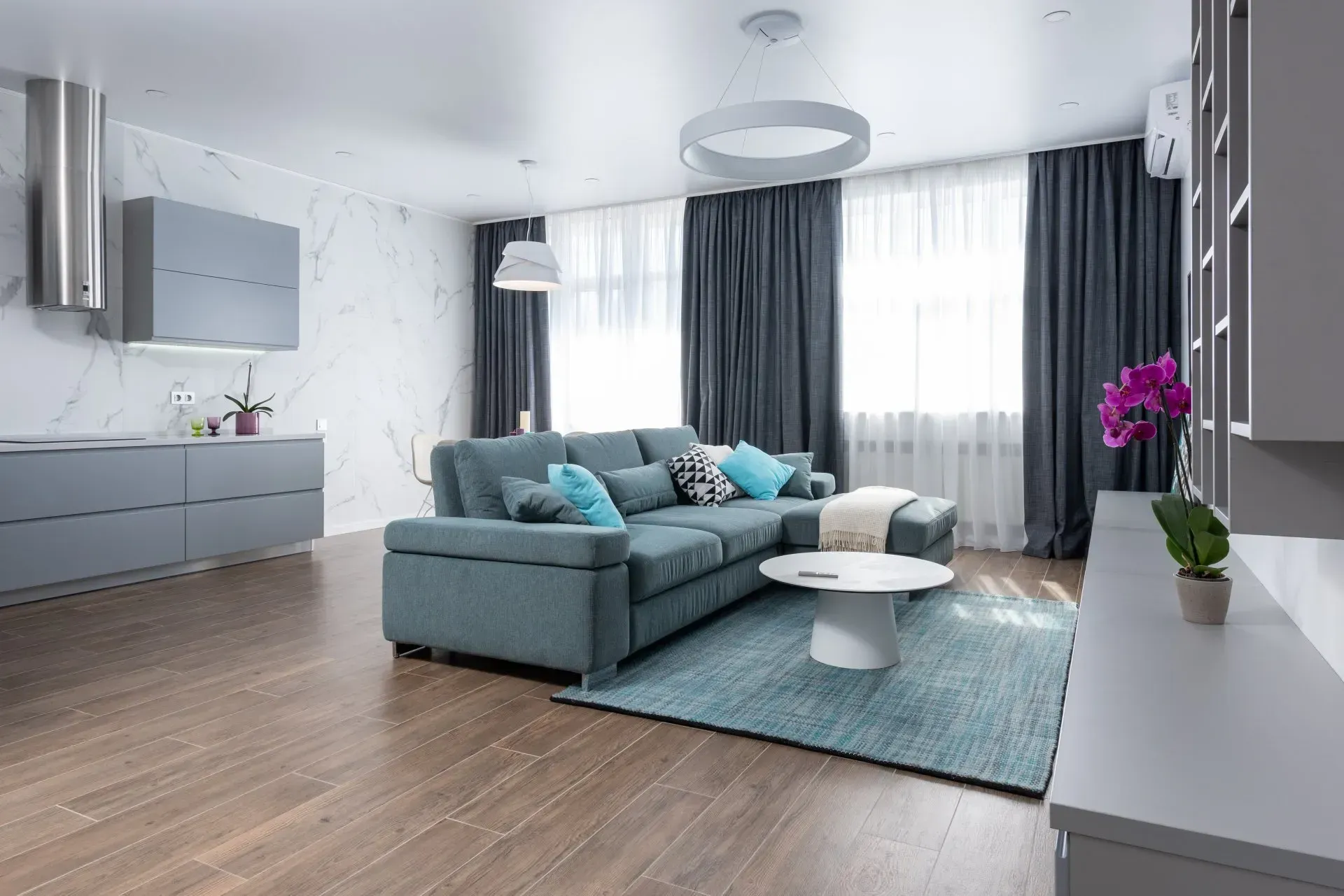 A living room with a blue sectional couch and a coffee table.