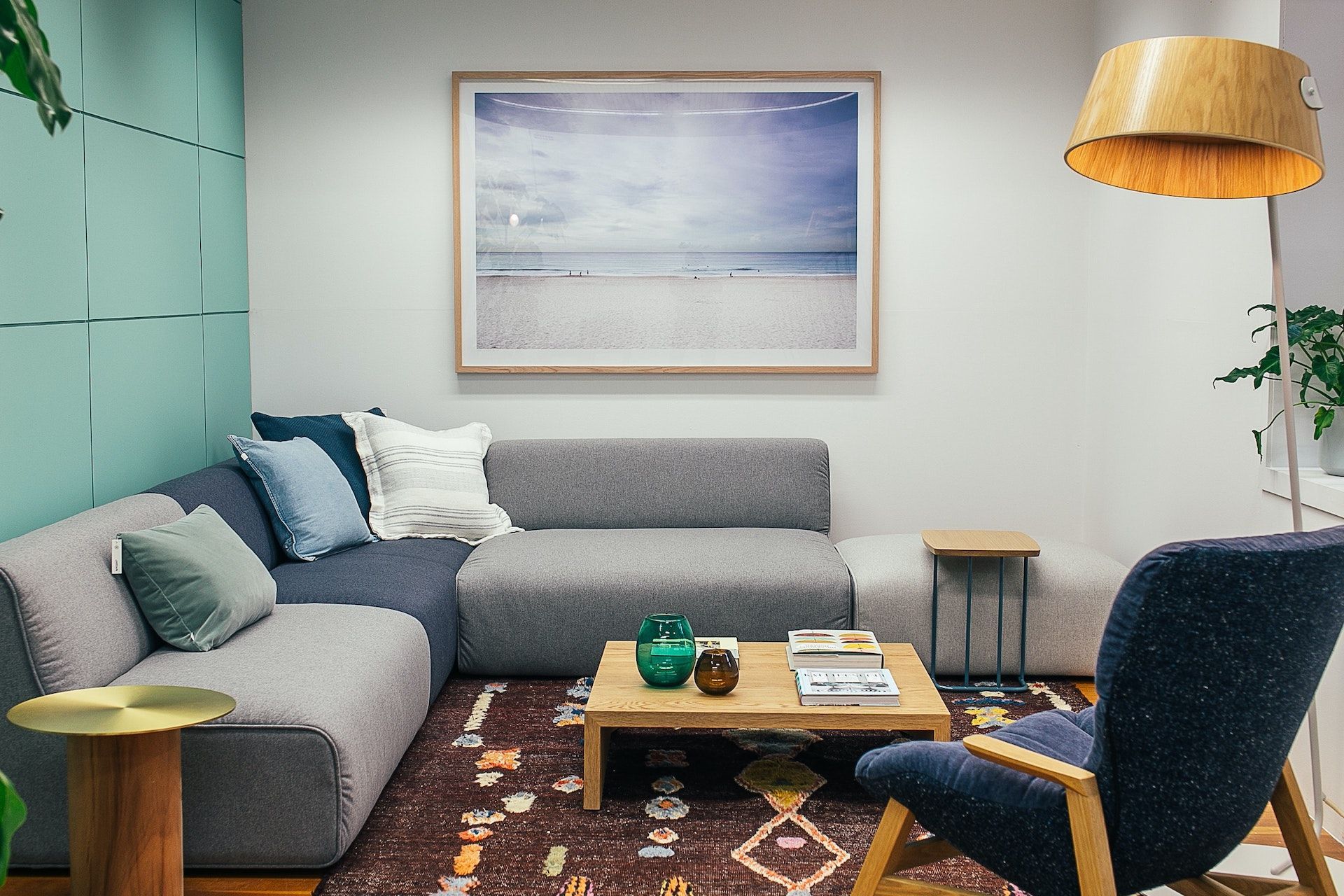 A living room with a couch , chair , coffee table and a picture on the wall.