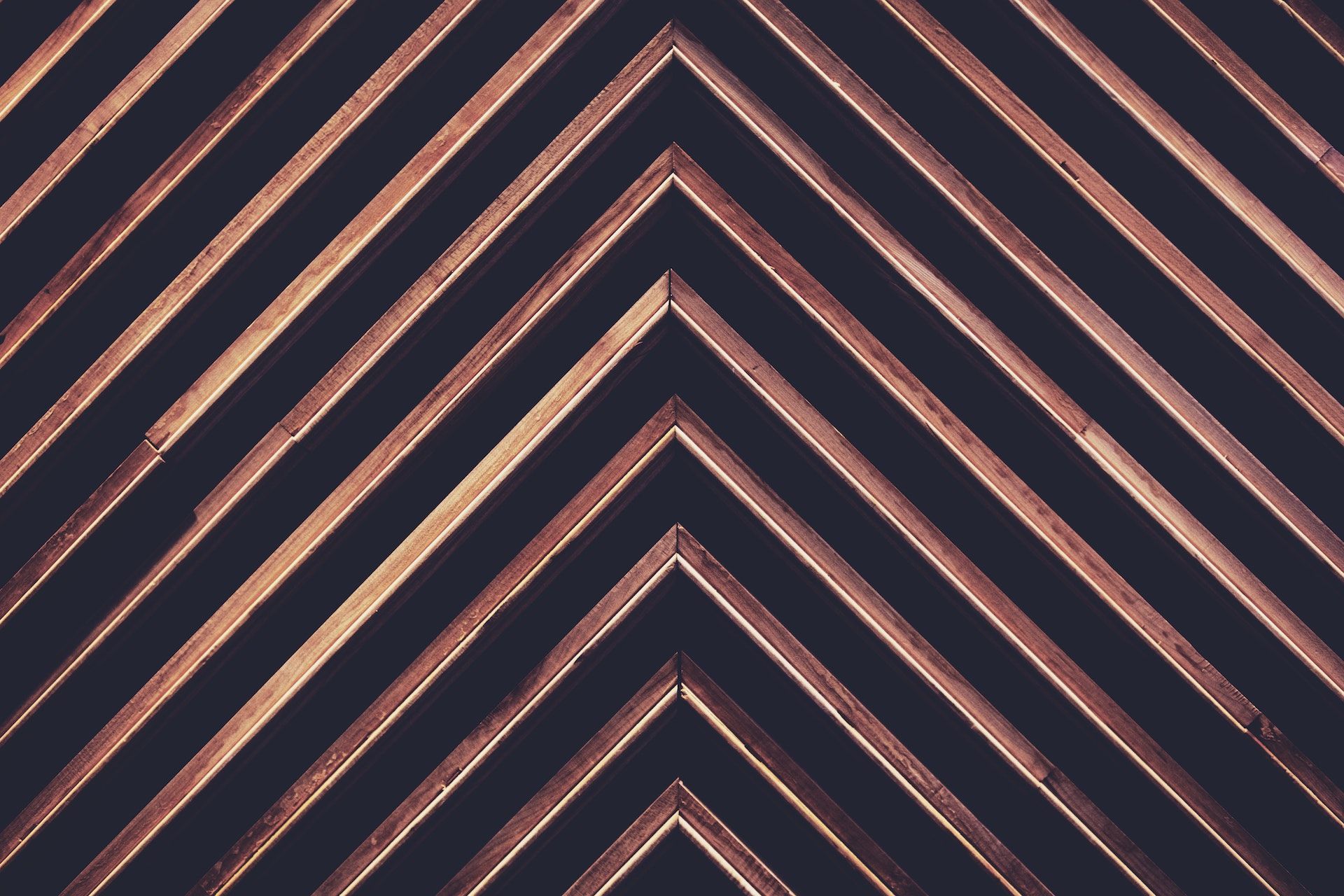 A close up of a wooden chevron pattern on a black background.