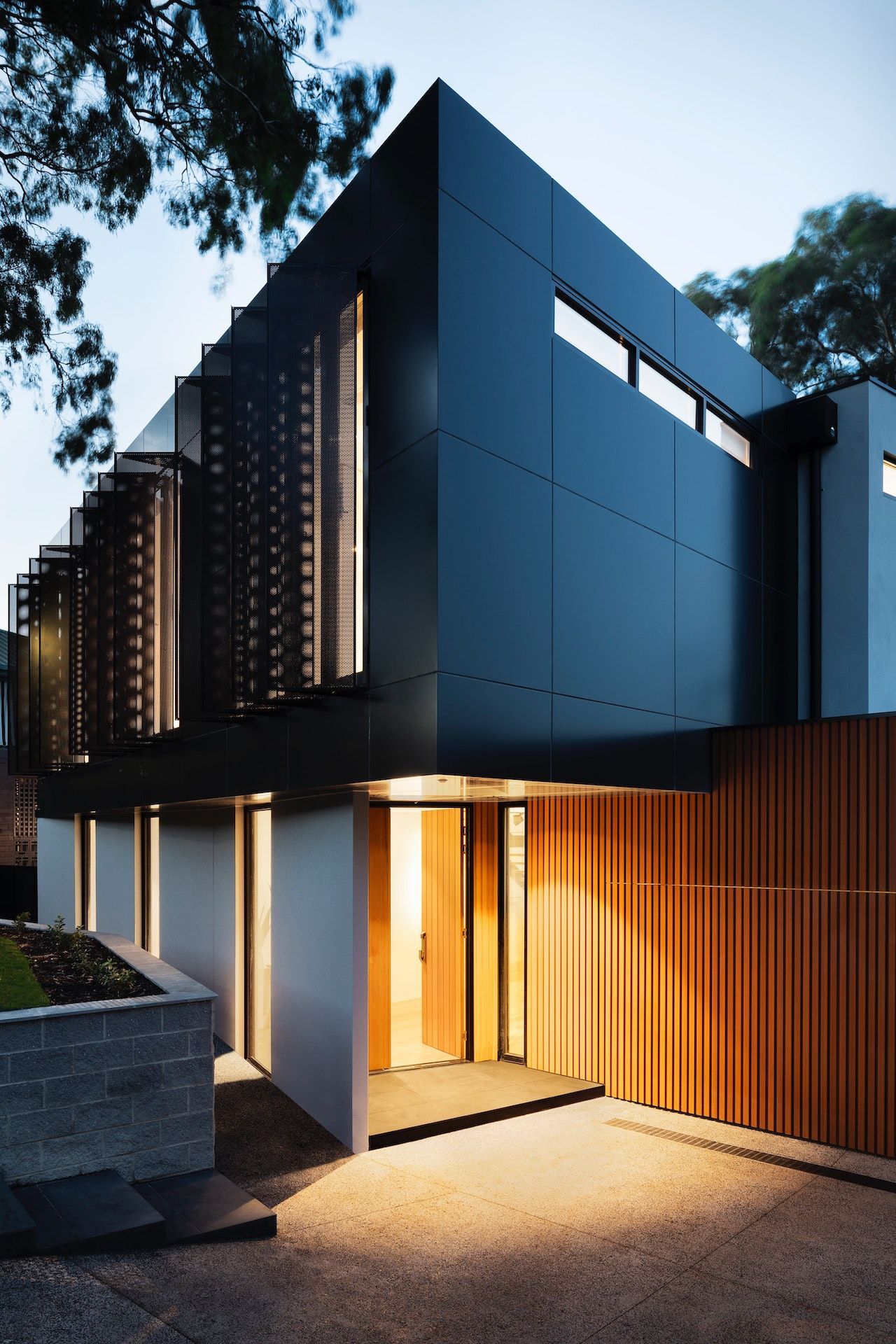 A modern house with a black facade and a wooden door
