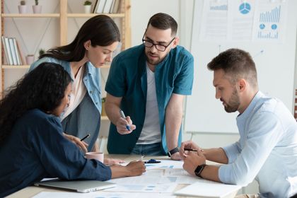 A group of people are sitting around a table having a meeting.
