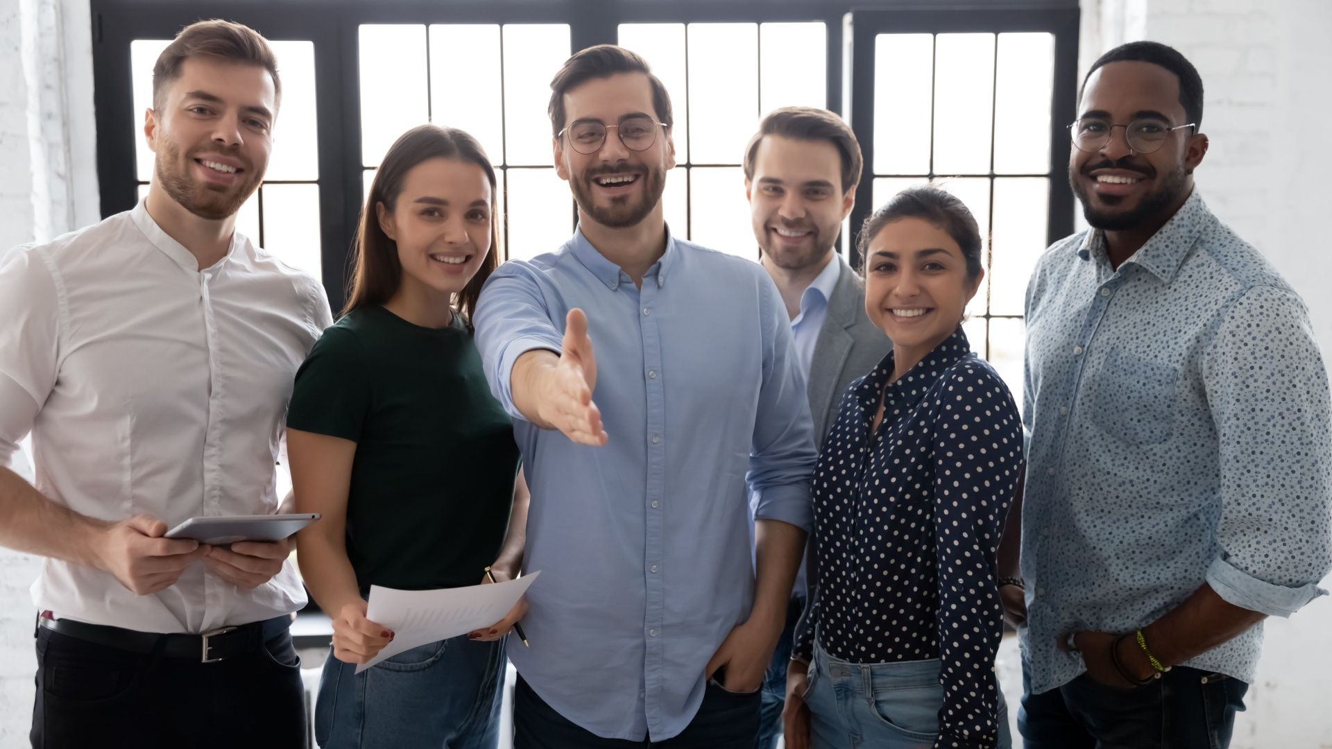 A group of people are standing next to each other in an office.