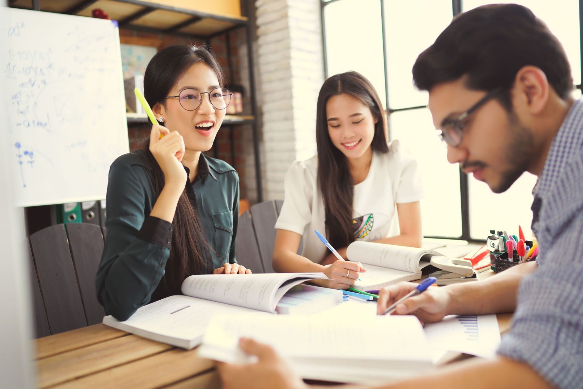 A group of people are sitting at a table having a meeting.