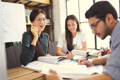 A group of people are sitting at a table having a meeting.
