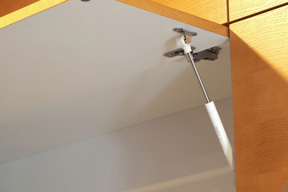 A Close up Of a Cabinet Door with A Lifter Attached to It — Strut Re-gas Mackay In Ooralea, QLD