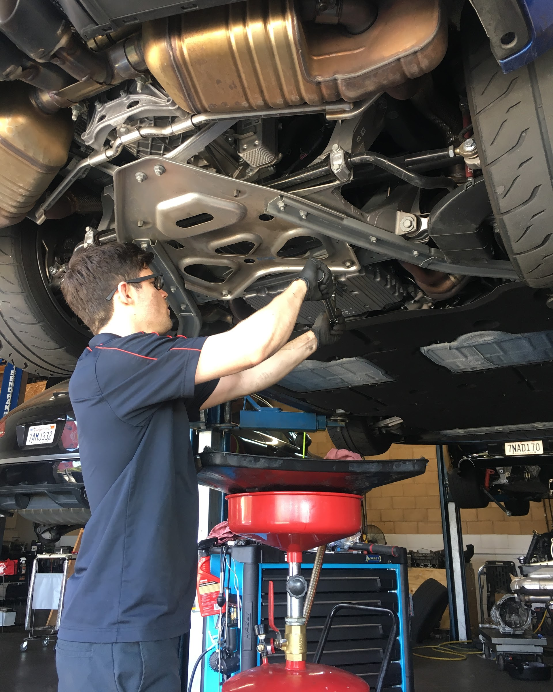 Mechanic working under a car in a garage | Koncept Motorwerks