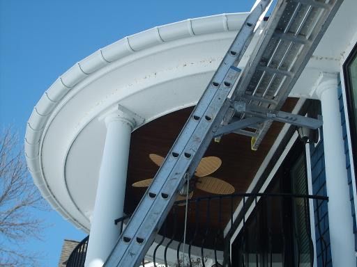 Close-up of a terracotta tile roof, showing rows of curved, reddish-brown tiles with dark areas in the grooves.