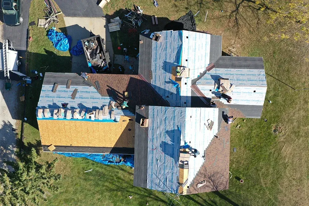 An aerial view of a row of houses with black roofs