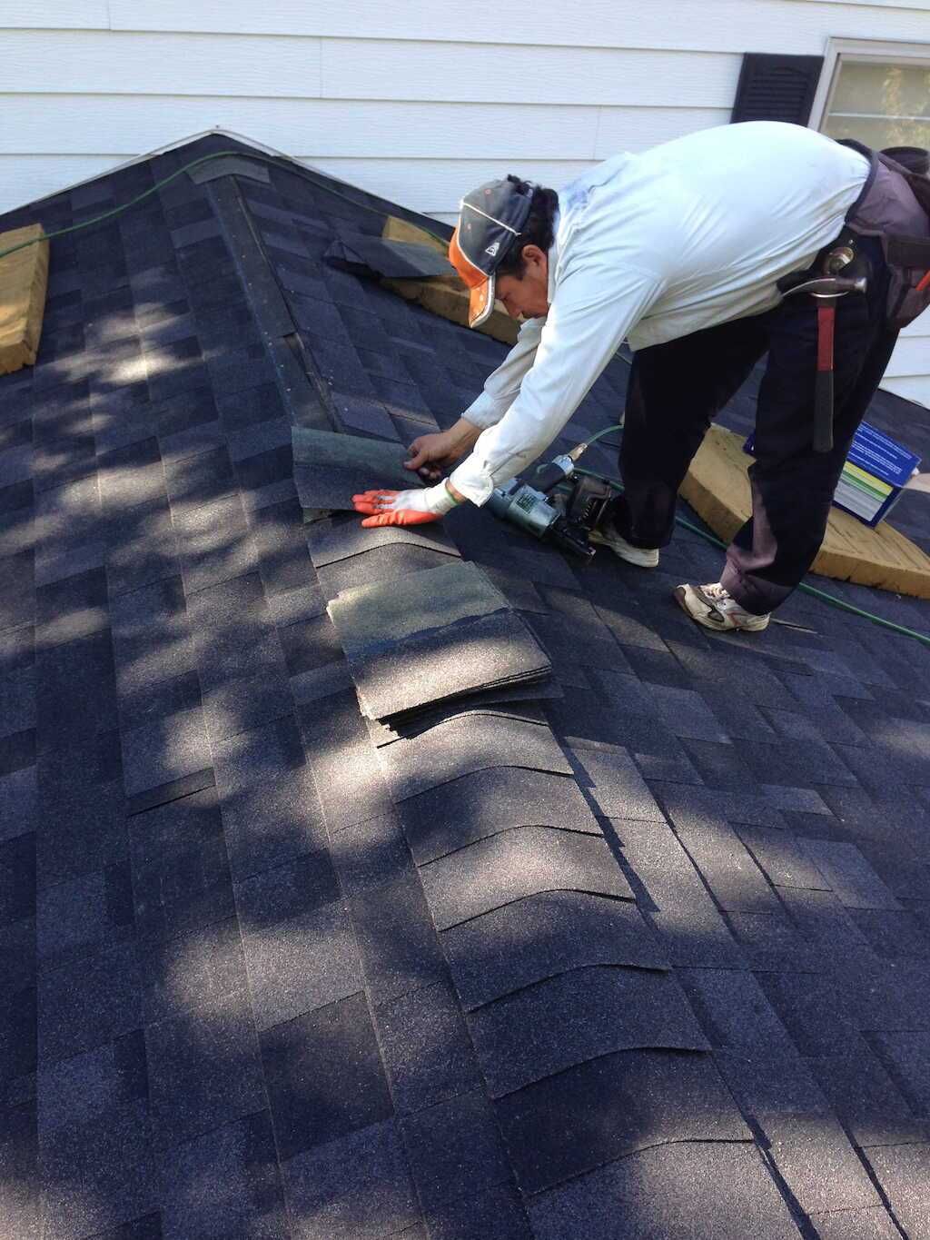 A man is working on the roof of a house.