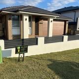 A house with a fence and a mailbox in front of it.