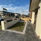 A house with a fence and a sidewalk in front of it.