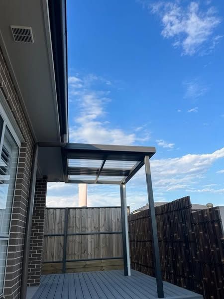 A deck with a canopy and a blue sky in the background
