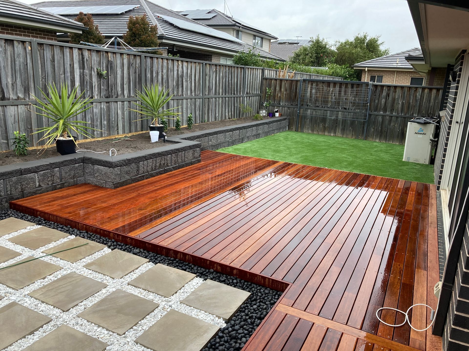 There is a wooden deck in the backyard of a house.