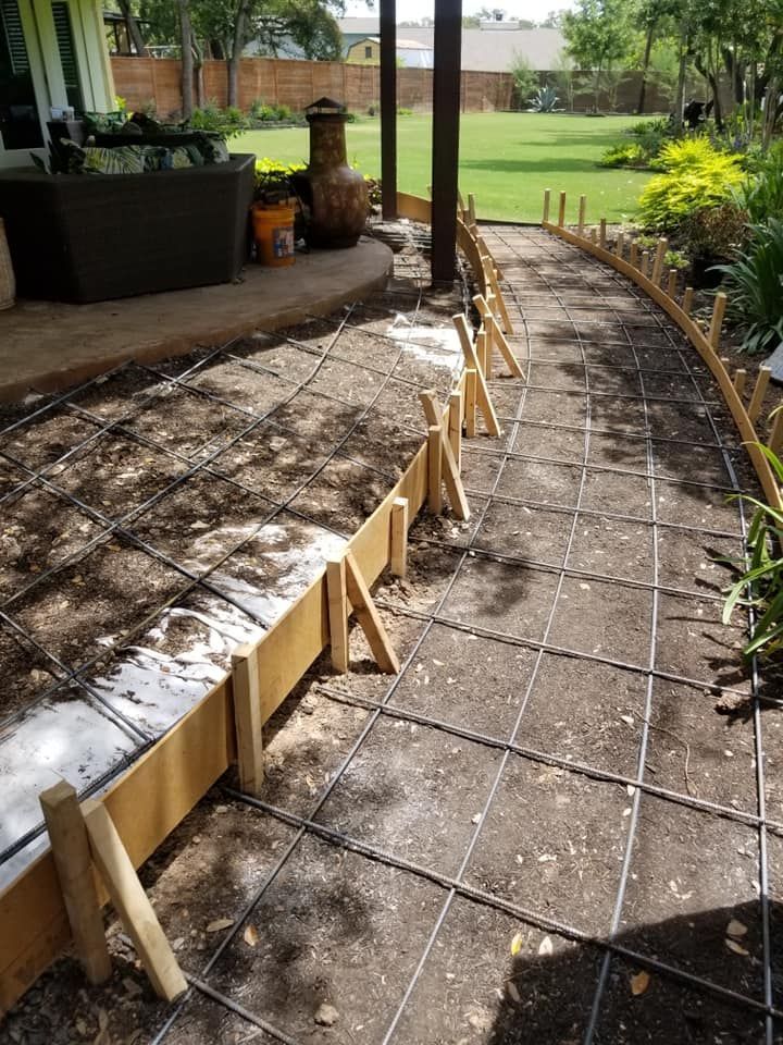 A concrete walkway is being built in front of a house.