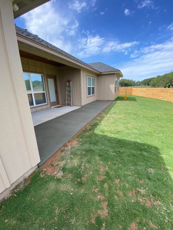 A house with a patio and a fence in the backyard.