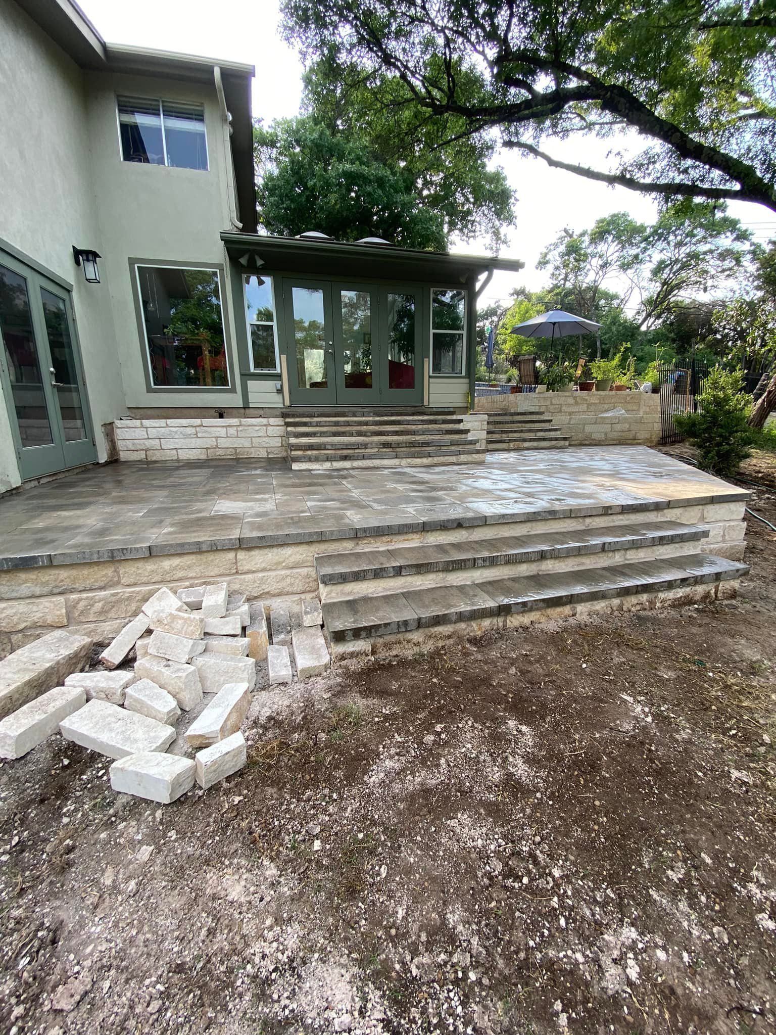 A large house with a patio and stairs in front of it.