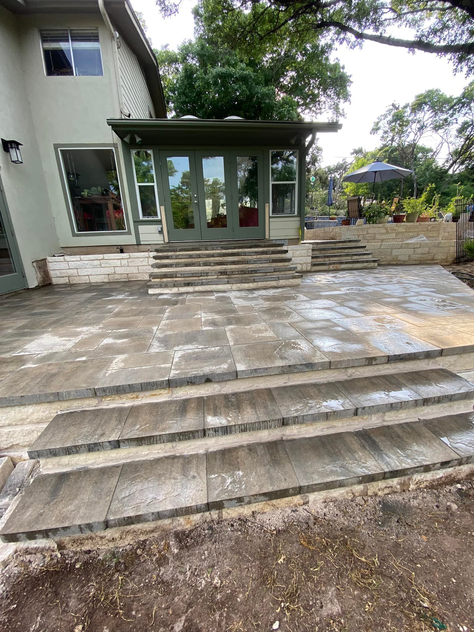 A patio with stairs leading up to a house.