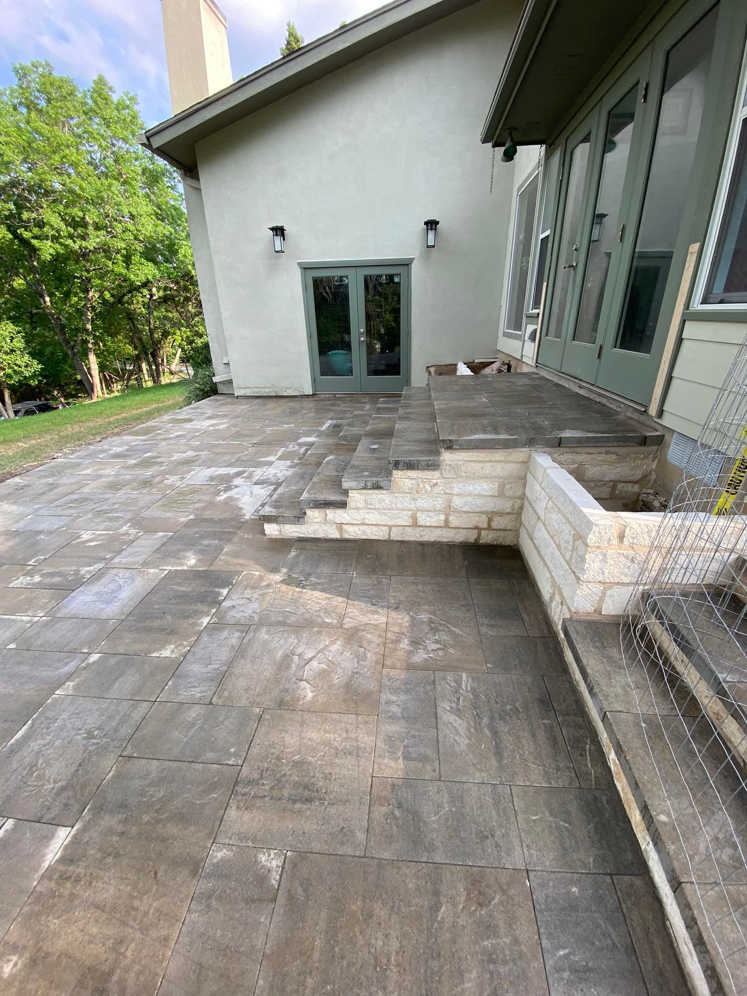 A patio with stairs leading up to a house.