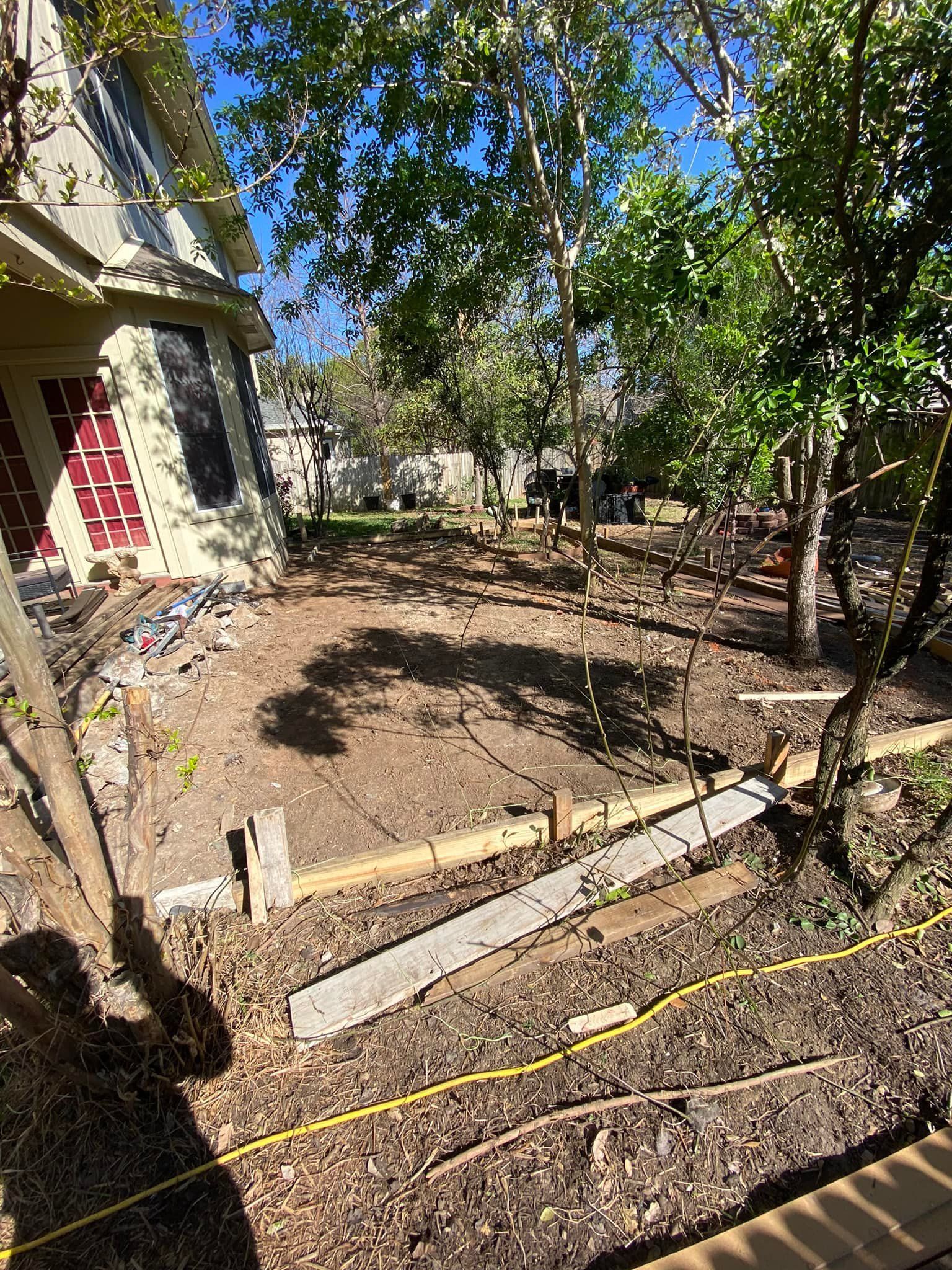 There is a house in the background and a lot of dirt in the foreground.