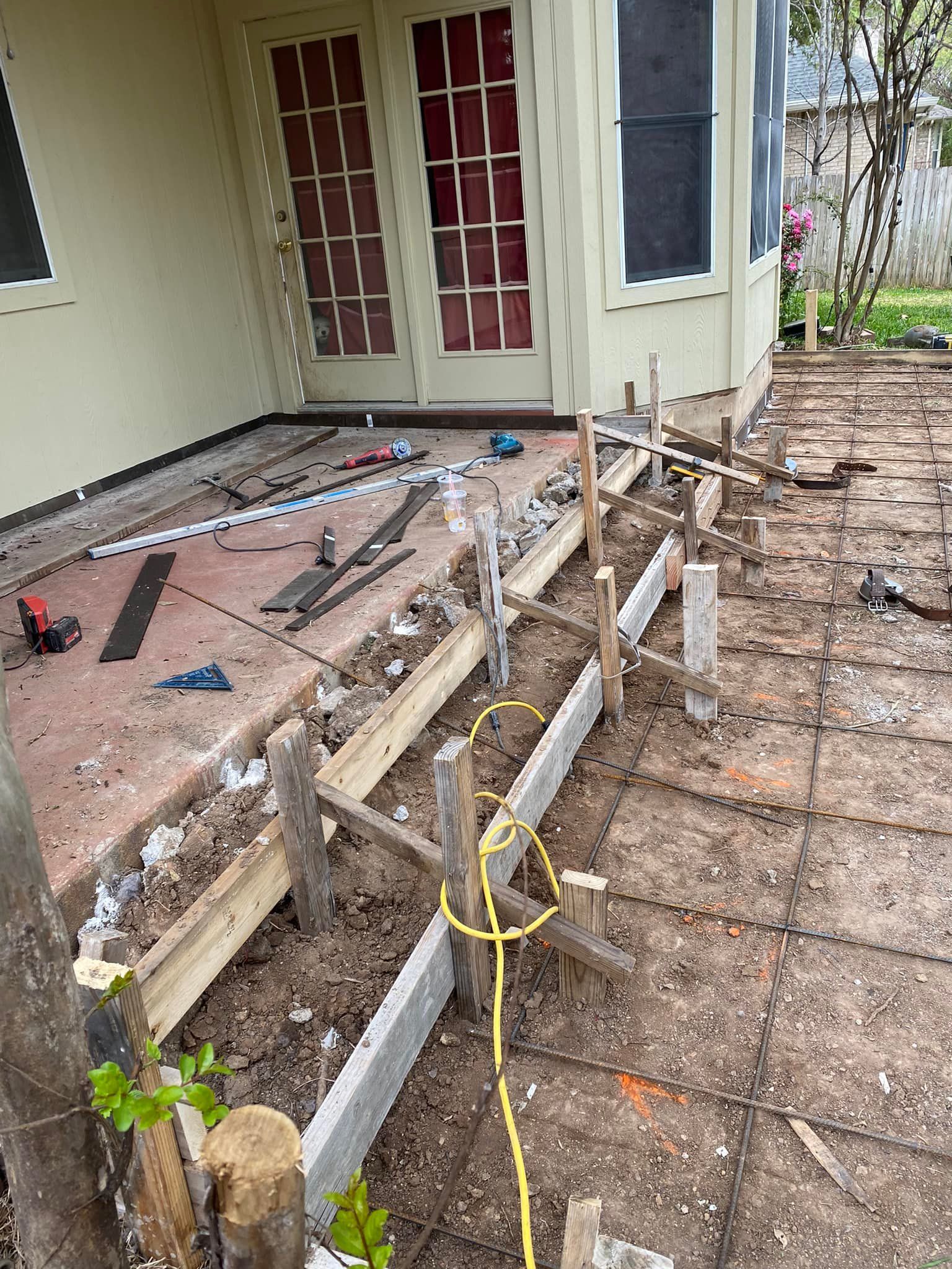 A patio is being built in front of a house.