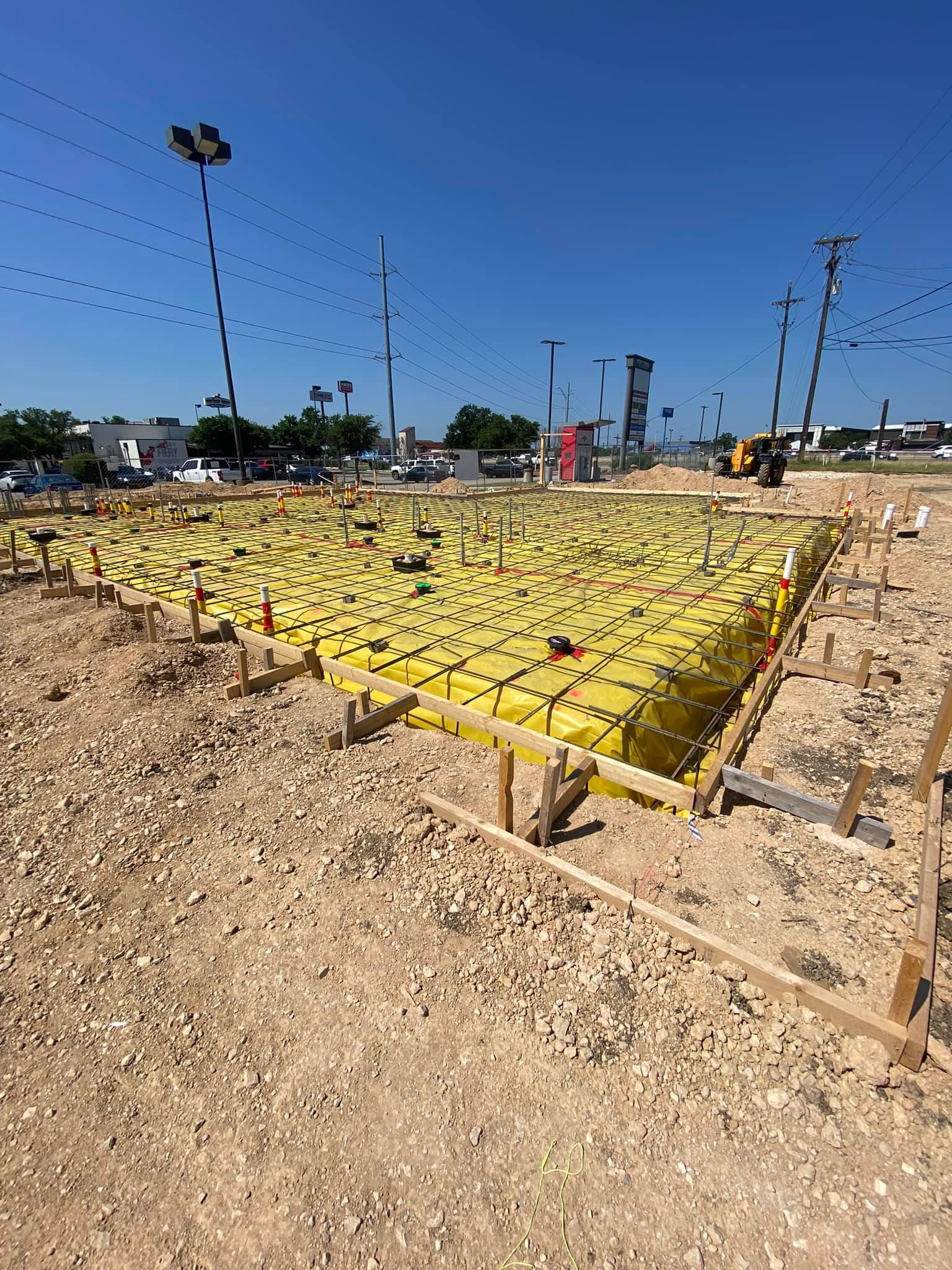 A construction site with a lot of yellow tarps on it.
