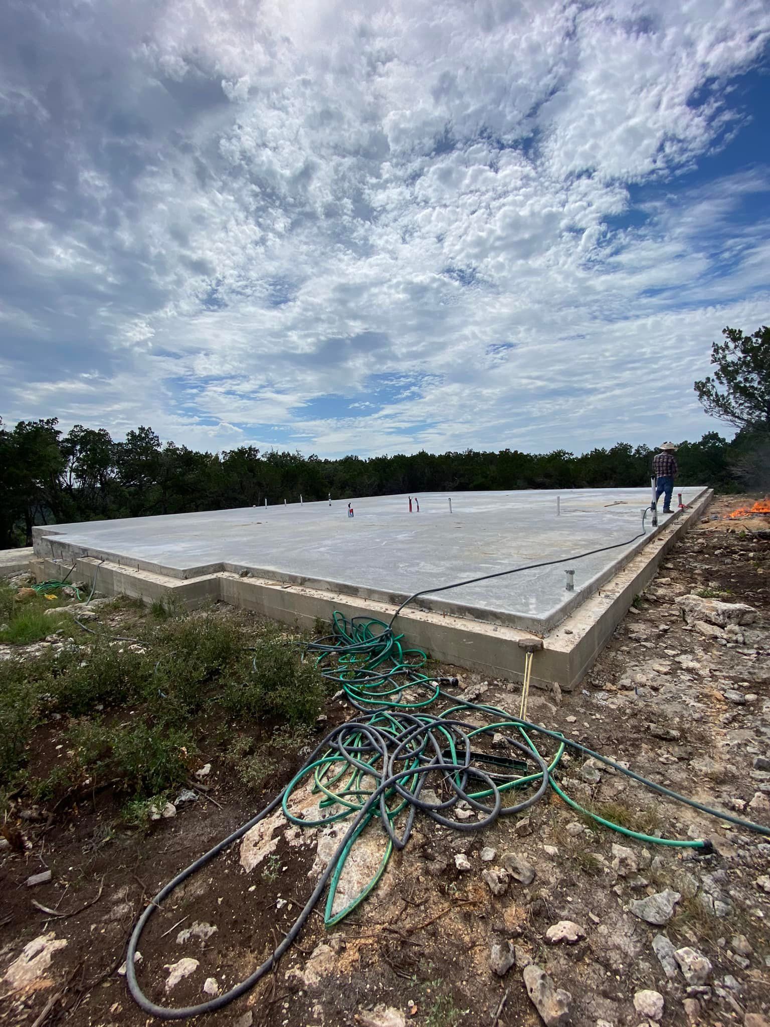 A hose is laying on the ground next to a large concrete slab.