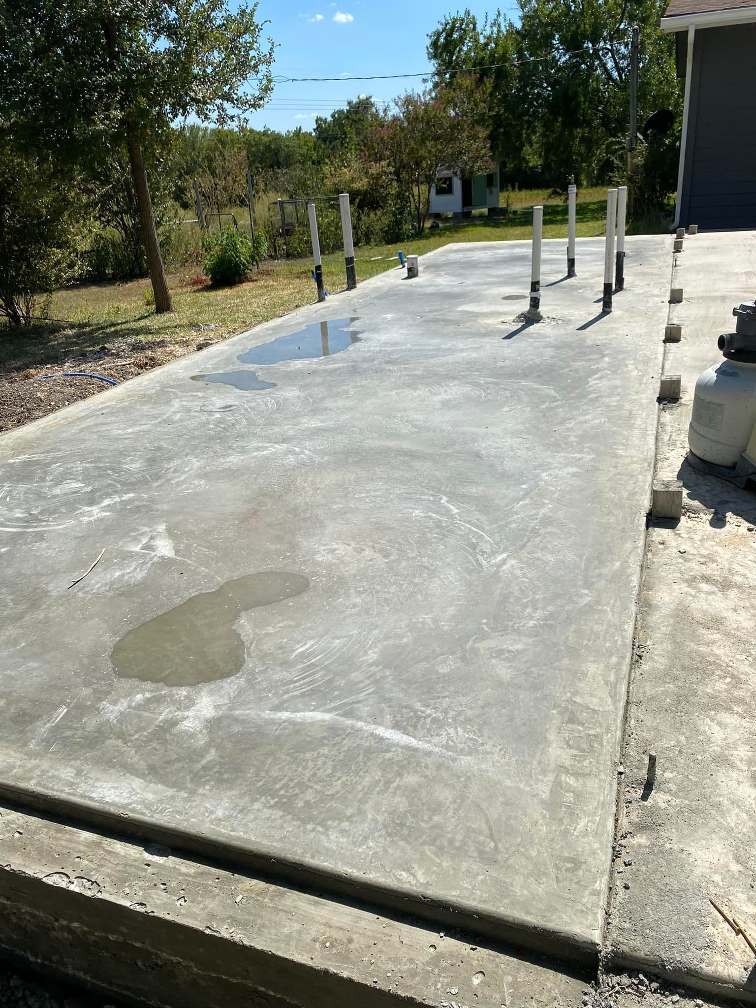 A concrete driveway is being built in front of a house.