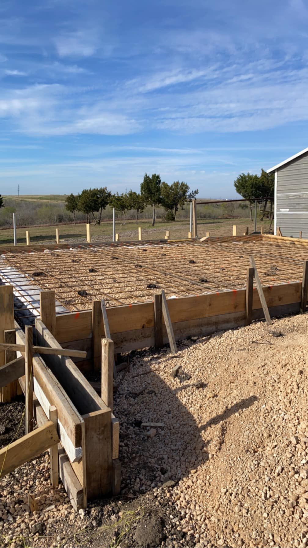 A building is being built in the middle of a dirt field.