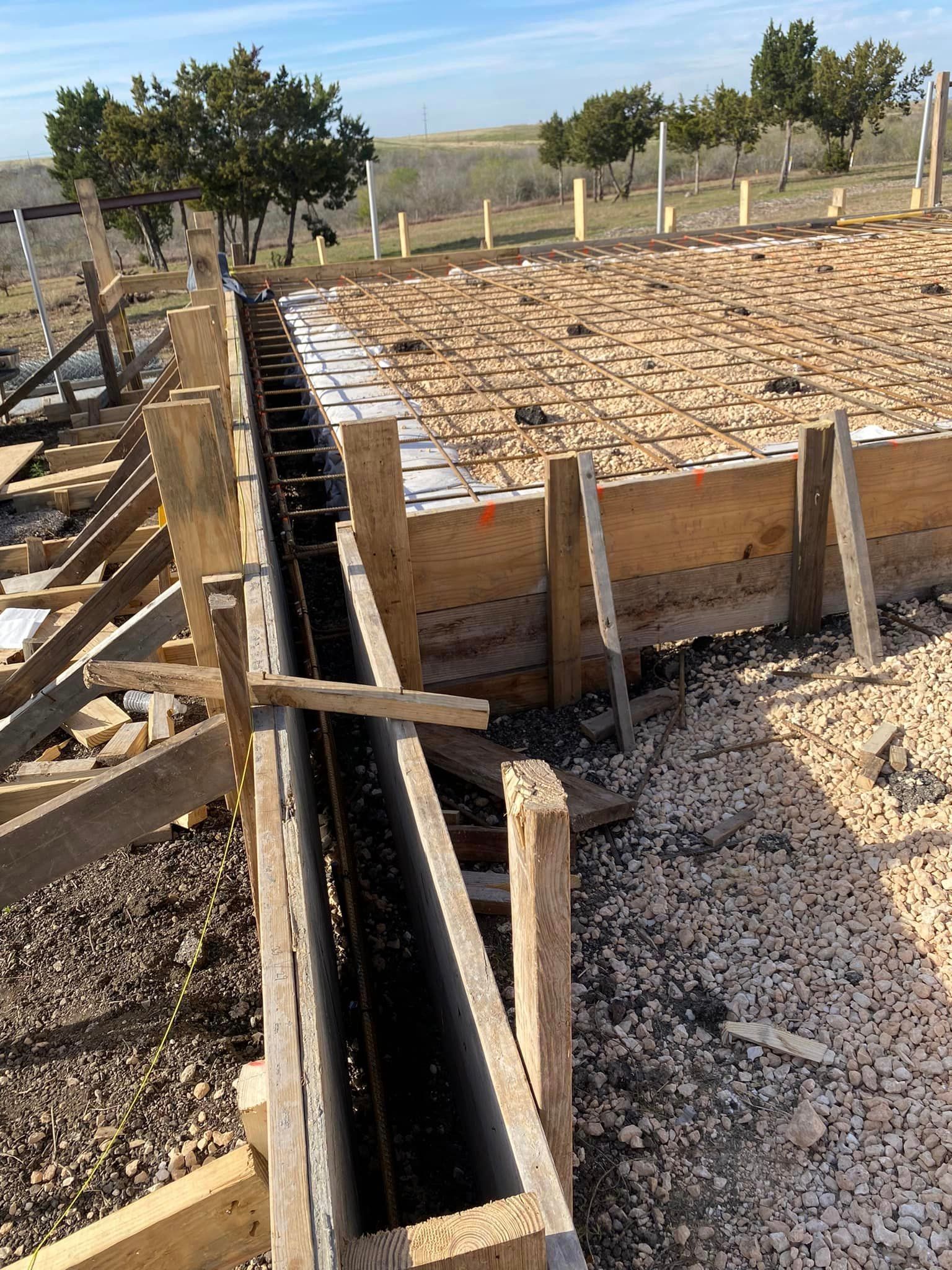 A wooden fence is being built in a field.