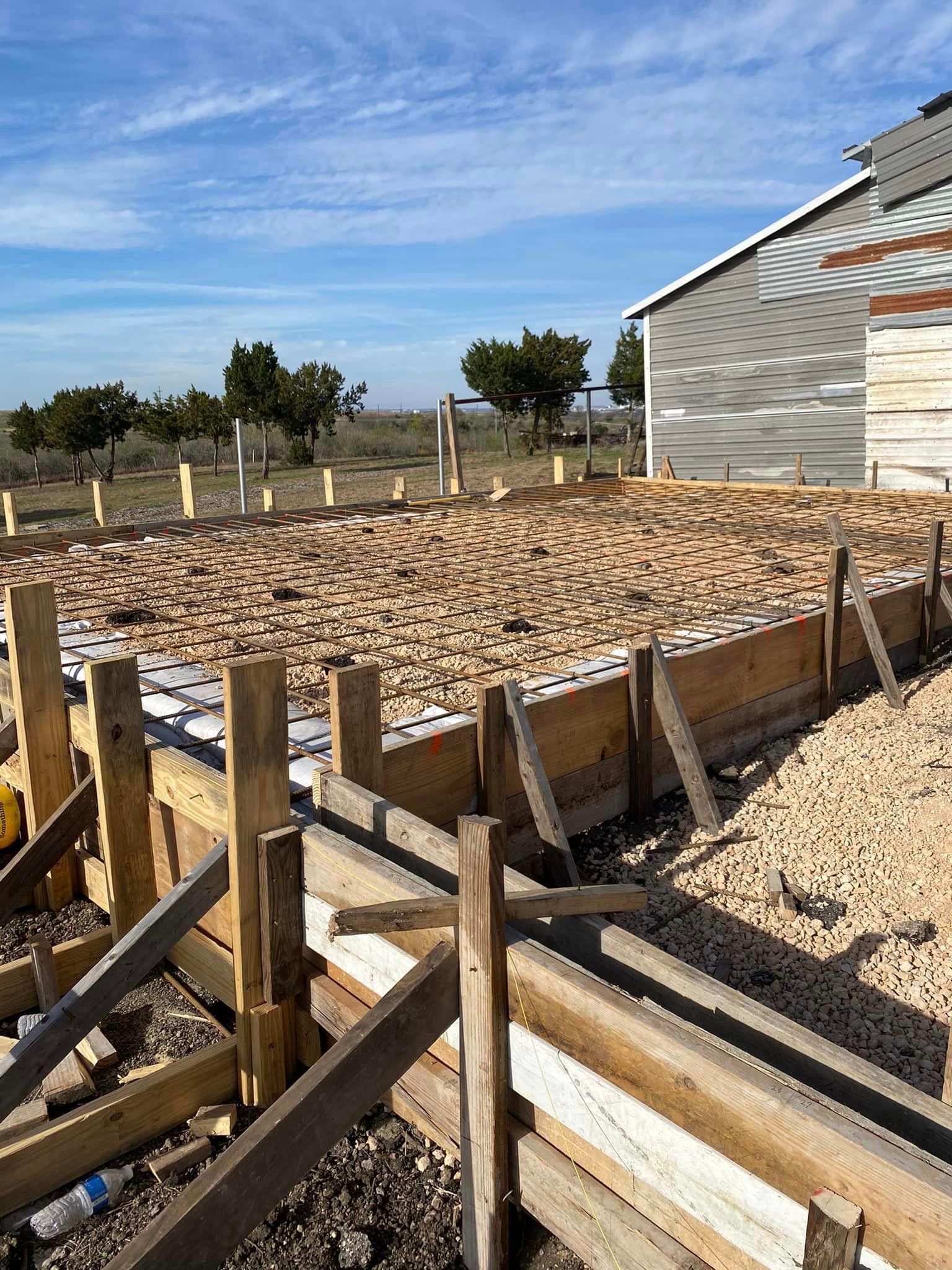A wooden fence is being built in front of a building under construction.