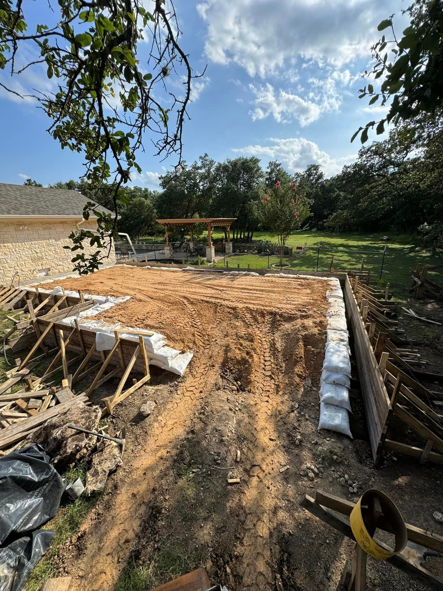 A construction site with a lot of dirt and trees in the background.