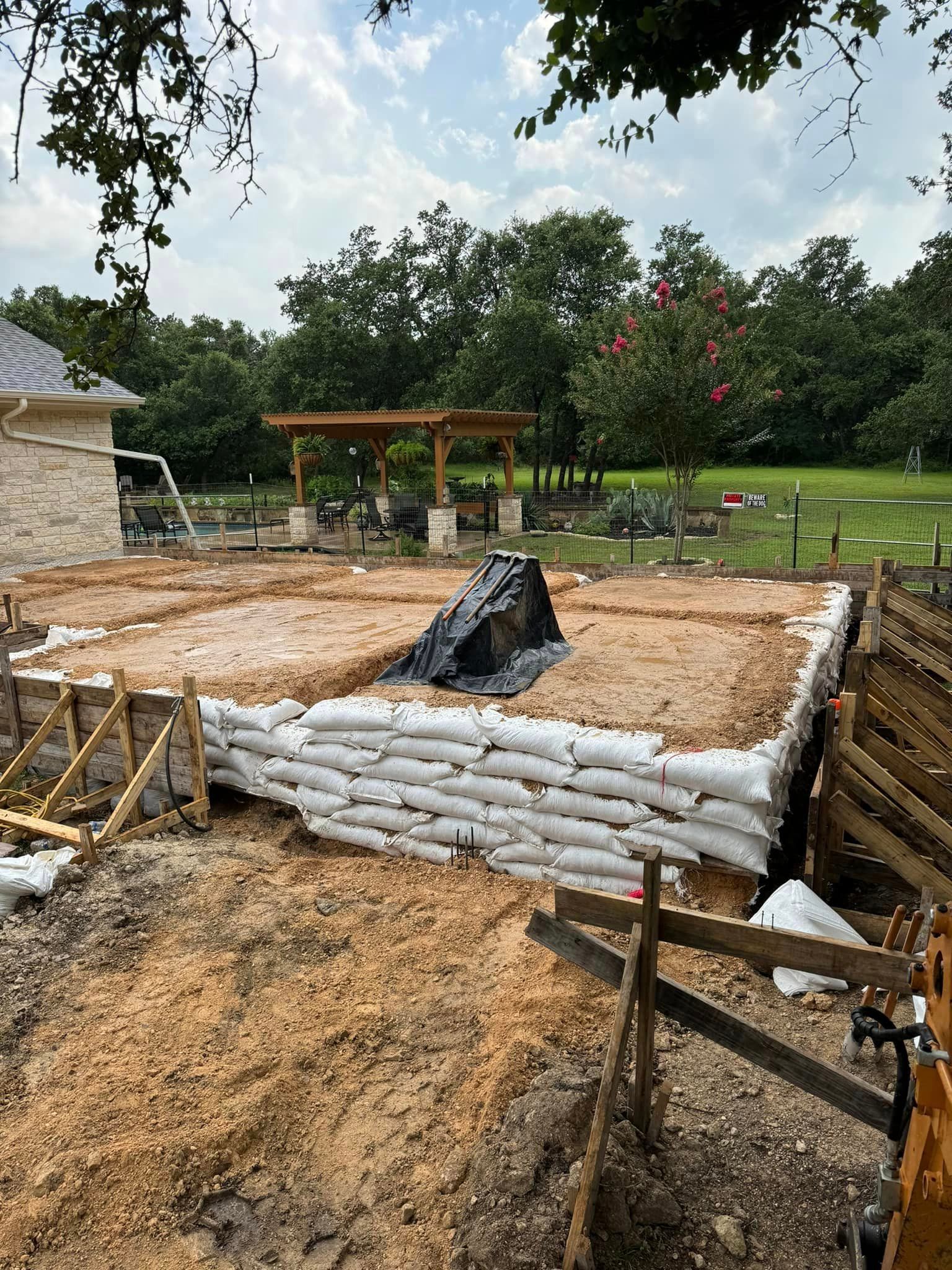 A pile of sandbags is sitting on top of a dirt field.